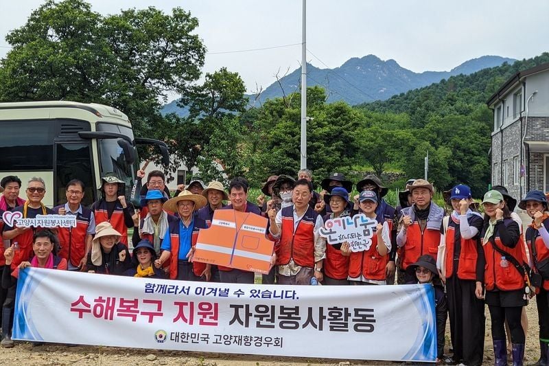 ▲ 고양재향경우회, 수해복구 자원봉사활동 후 "함께라서 이겨낼 수 있습니다!" 현수막 앞에서 단체 기념사진 촬영.