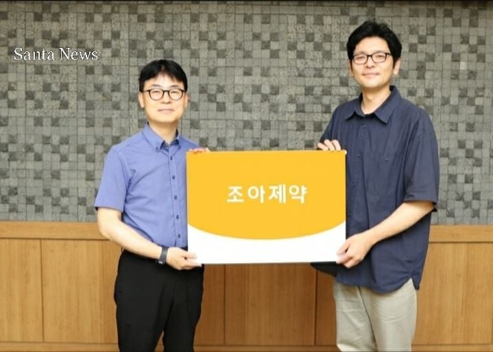 고정관 조아제약 기획홍보실장(왼쪽)과 전민혁 지파운데이션 대외협력팀 과장이 기념 촬영을 하고 있다. [사진  AI 유사 생성 이미지] 