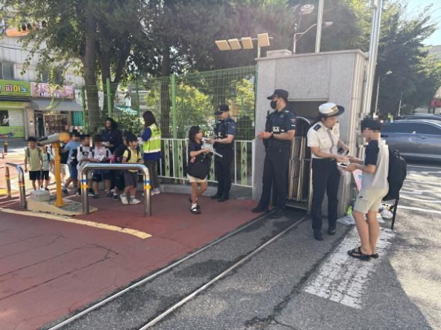 로보캅순찰대와 경찰이 18일 관내 초·중학교에서 등하굣길 안전캠페인을 진행하고 있다. [사진제공 안산시]