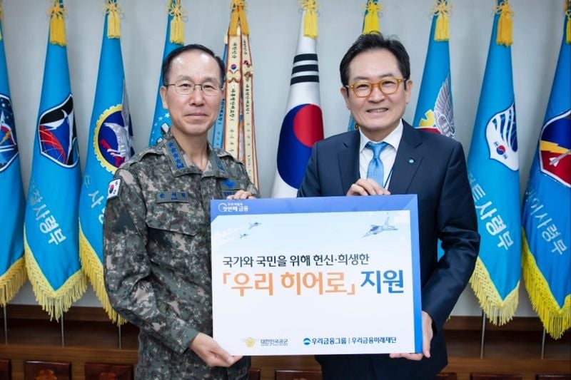 왼쪽부터) 손석락 공군 참모총장과 장광익 우리금융미래재단 사무국장이 지난 28일 계룡대에서 공군에게 지원금을 전달하고 기념촬영을 했다. [우리금융그룹]