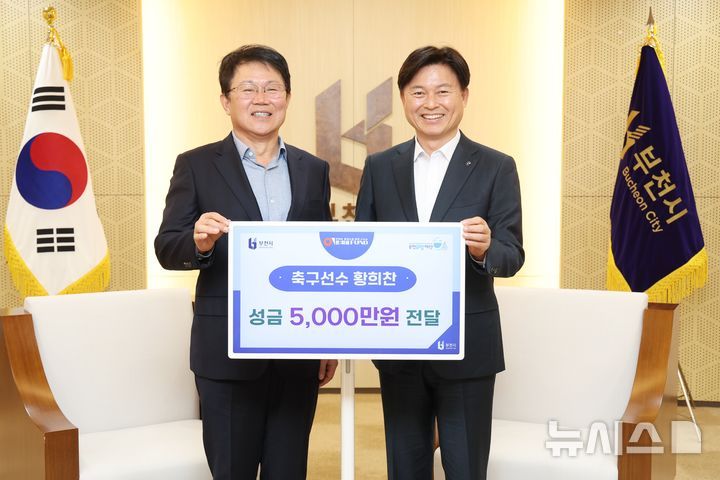 부천=뉴시스]정일형 기자 = 황희찬 선수 아버지 황원경씨가 조용익 부천시장에게 5000만 원을 전달한 뒤 기념사진을 찍고 있다. [사진재공 부천시]
