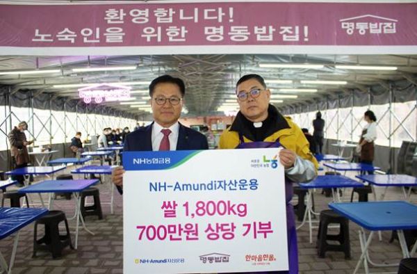 10일 무료 급식소 '명동밥집'에서 길정섭 NH-아문디자산운용 대표이사, 명동밥집 센터장 백광진 신부가 기념 사진을 촬영하고 있다. [사진제공 NH-아문디자산운용]