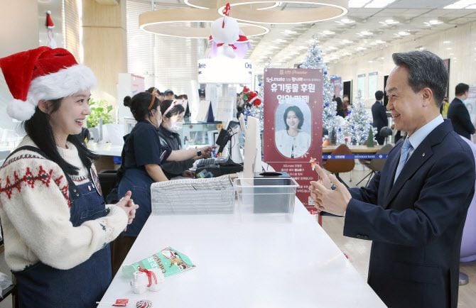 18일 서울 중구 신한금융그룹 카페스윗에서 진옥동 신한금융그룹 회장(오른쪽)이 유기동물 보호를 위한 기부활동을 진행한 후 배우 장나라씨에게 수어로 직접 커피를 주문하고 있다. [사진제공 신한금융]