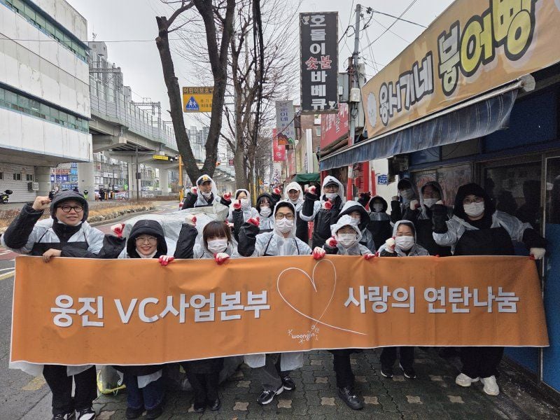 웅진그룹 임직원들이 지난 23일 서울 노원구에서 연탄 나눔 봉사활동에 앞서 기념촬영을 하고 있다. 웅진그룹 제공