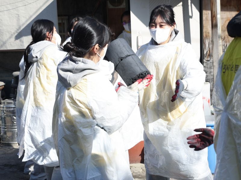 동서식품 직원들이 27일 서울 송파 화훼마을에서 연탄 나눔 봉사활동을 하는 모습. [제공=동서식품]