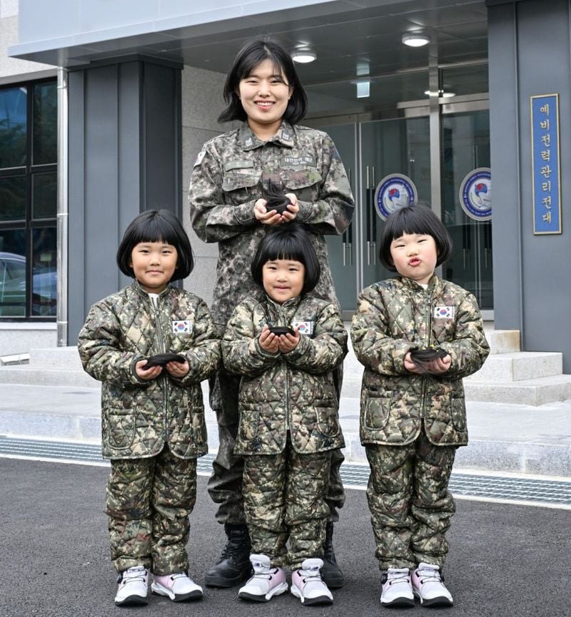 해군 제8전투훈련단 소속 이은주 상사와 세쌍둥이 딸 장은진·소진·유진양이 지난달 26일 8전단 예하 예비전력관리전대 건물 앞에서 각 25cm 길이의 머리카락을 손에 들고 기념 촬영하고 있다. (해군 제공)