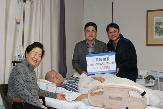 이주용(왼쪽 두번째) 시스원 명예회장과 그 배우자 최기주(왼쪽) 씨가 시스원 이상훈(왼쪽 세번째) 부회장 및 고영민 경영지원실장과 함께 직원 복지를 위한 40억원 기탁금 전달을 기념해 포즈를 취하고 있다. (사진=시스원)