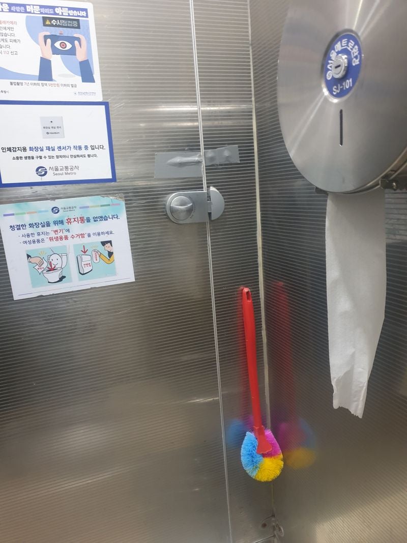 문 안쪽에 걸려 있는 변기 솔