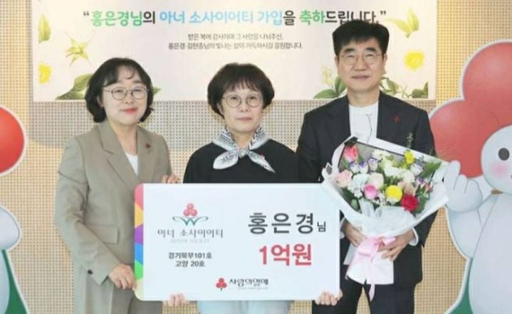 홍은경 전 교사가 14일 사랑의열매에 1억원을 기부하고  기념사진을 찍고 있다. 왼쪽부터 경기북부 사랑의열매 이경아 본부장과 홍 전 교사, 홍 전 교사의 남편 김현종씨. [사진제공 사랑의열매]