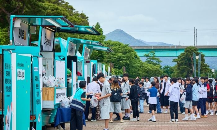 23일 부산 강서구 강서체육공원에서 전국소년체전 참가자들이 배달의민족과 주요 외식 브랜드가 함께 마련한 푸드트럭에서 음식을 받고 있다. [우아한형제들]