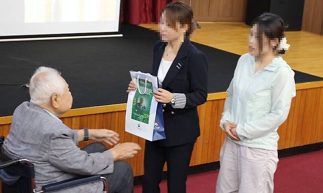 통일부 북한이탈주민정착지원사무소(하나원) 수료식에서 교육생들에게 직접 최신 휴대전화를 증정하는 양한종 씨(왼쪽). [사진제공 통일부]