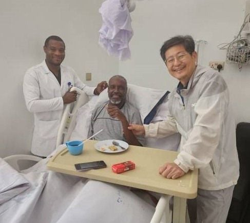 김용민 전 충북대 의과대학 교수(오른쪽)가 해외 의료봉사 현장에서 병상의 환자와 웃으면서 사진 촬영을 하고 있다. JW이종호재단