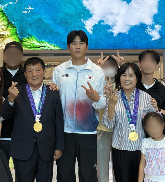한국 카누 차세대 스타 김효빈(왼쪽에서 세 번째)이 지난달 27일 인천국제공항에서 이공헌 씨(왼쪽에서 두 번째)와 최현숙 씨(왼쪽에서 다섯 번째)의 목에 2026 아이치-나고야 아시안게임에서 획득한 금메달을 하나씩 걸어준 뒤 기념 촬영을 하고 있다. [사진제공 김효빈]