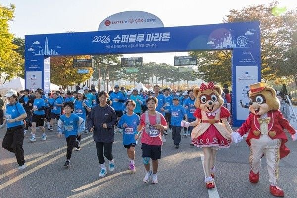 롯데가 지난 9일 서울 상암동 평화의공원에서 개최한 ‘제11회 슈퍼블루마라톤’에서 장애인과 비장애인 참가자들이 손을 맞잡고 함께 달리고 있다. 이날 행사에는 약 8000명이 참여했다. (사진 제공=롯데)